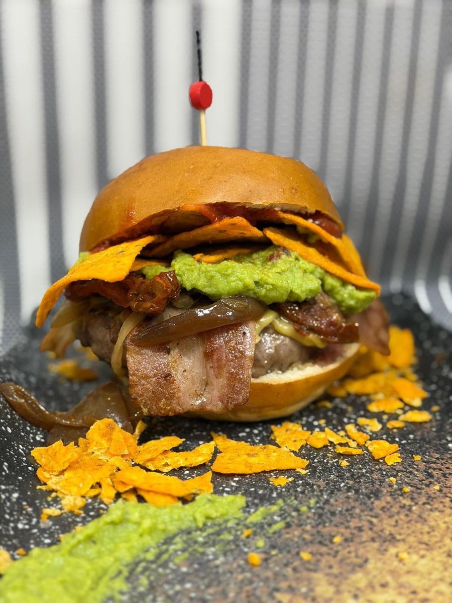 Hamburguesa con bacon, nachos, guacamole y cebolla caramelizada